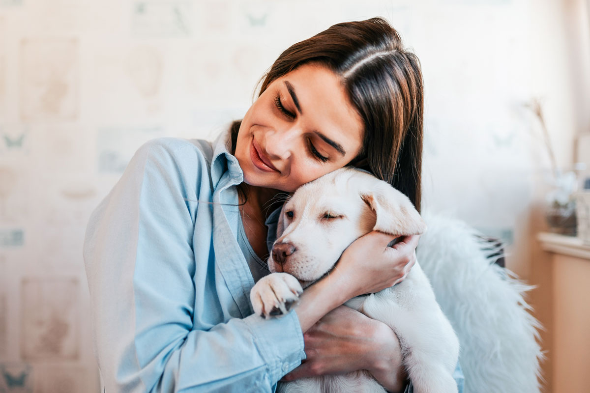 beautiful-girl-hugging-her-puppy-at-home