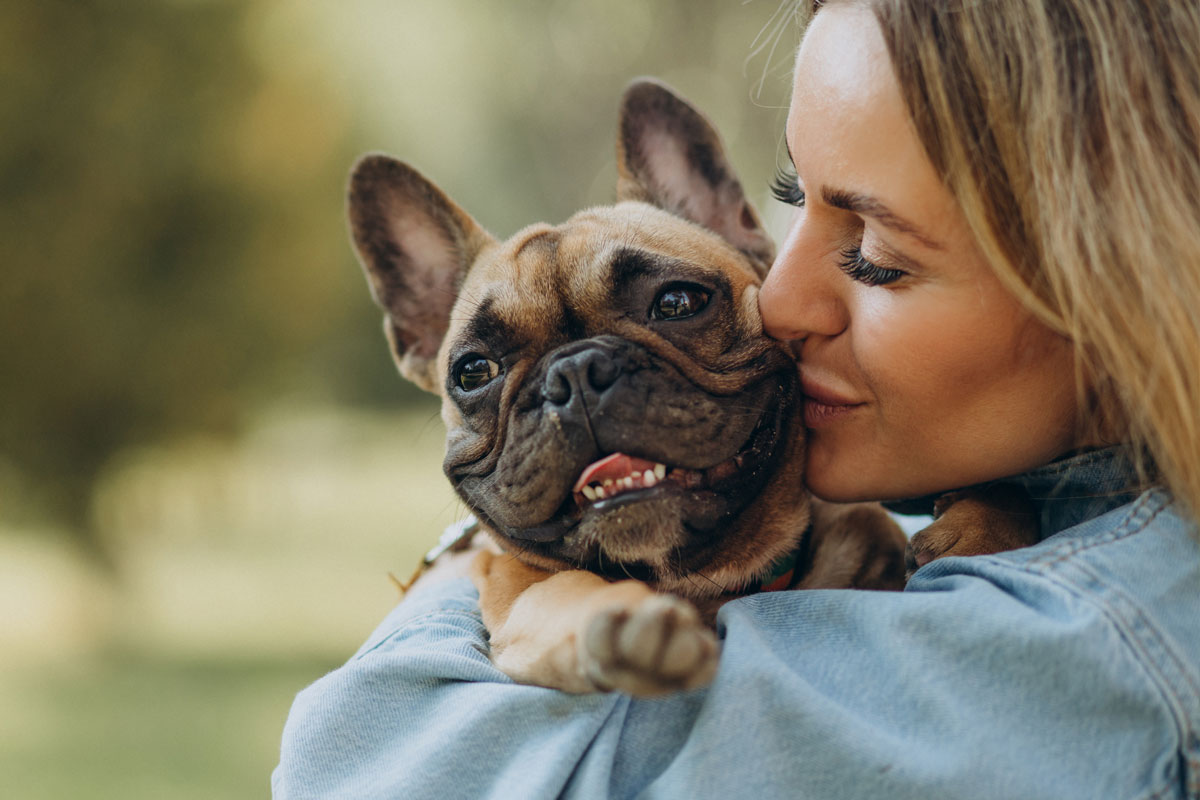 young-woman-with-her-pet-french-bulldog-in-park